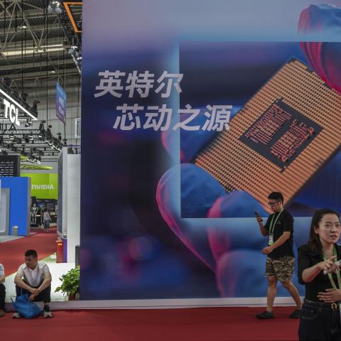 Visitors walk by a billboard showing a semiconductor chip at the Chinese International Supply Chain Expo on June 26, 2026, in Beijing, China. (Getty Images)