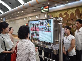 Commuters in the Kaeson Station of the Pyongyang Metro look at a screen with the newspaper “Rodongsinmun” showing news about Xi Jinping’s visit to North Korea on June 9, 2026. (Getty Images)
