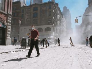 An unidentified man with a face mask walks on an ash-covered street near Ground Zero after the collapse of the Twin Towers on September 11, 2001, in New York City. (Getty Images)