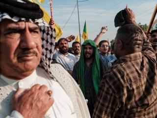 Supporters of the Popular Mobilisation Forces (PMF) chant slogans and wave flags at a rally celebrating the end of the US military presence in Iraq on September 30, 2026, in Baghdad, Iraq. (Getty Images)
