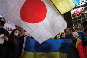 Protesters hold signs and chant slogans during a protest in front of the Shibuya Station on February 24, 2022, in Tokyo, Japan. (Getty Images)