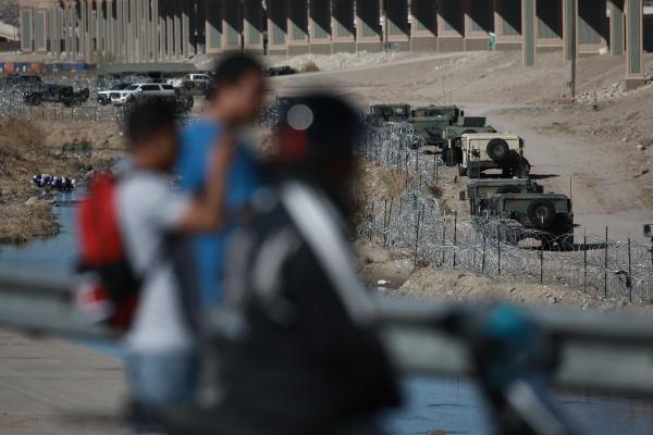 CIUDAD JUAREZ, MEXICO - JANUARY 08: Texas National Guard soldiers stand guard as migrants continue to wait at the U.S.-Mexico border on January 08, 2023 in Ciudad Juarez, Mexico. President Joe Biden made his first visit since taking office to the US-Mexico border on Sunday, spending four hours in El Paso in the US state of Texas. El Paso is currently the biggest corridor for illegal crossings in the US. (Photo by Christian Torres/Anadolu Agency via Getty Images)