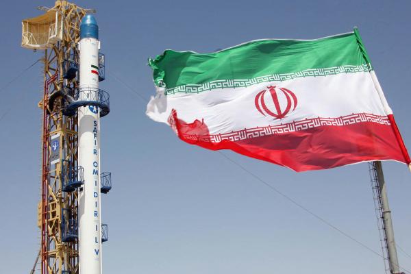 An Iranian flag fluttering in front of Iran's Safir Omid rocket at an undisclosed location on August 16, 2008. (Vahidreza Alai/AFP via Getty Images) 