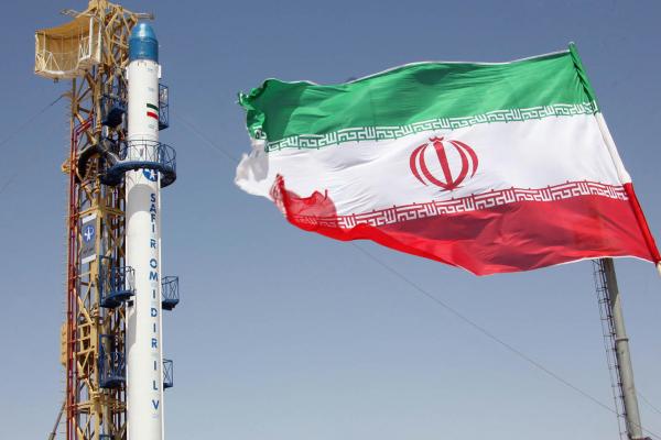 An Iranian flag fluttering in front of Iran's Safir Omid rocket at an undisclosed location on August 16, 2008. (Vahidreza Alai/AFP via Getty Images) 