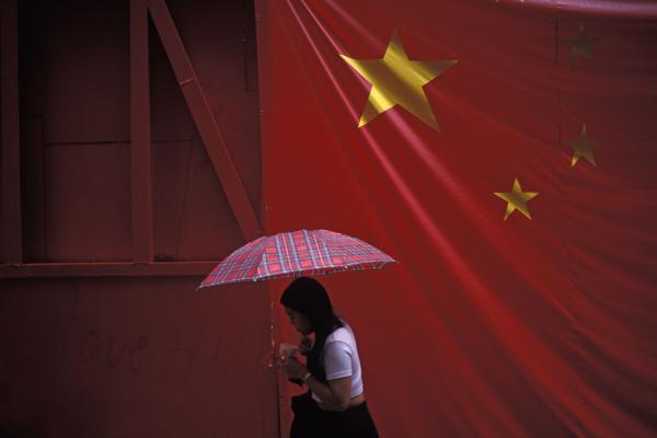 A Chinese flag hangs over a pedestrian in Hong Kong. (Richard Baker / In Pictures via Getty Images)