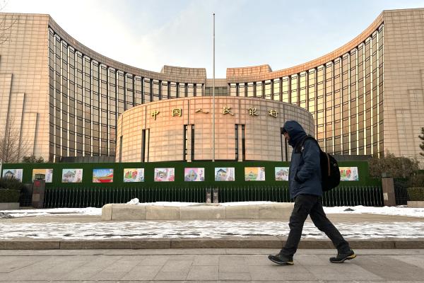 A man walks past the People's Bank of China building on December 25, 2023, in Beijing, China. (Jiang Qiming/China News Service/VCG via Getty Images)