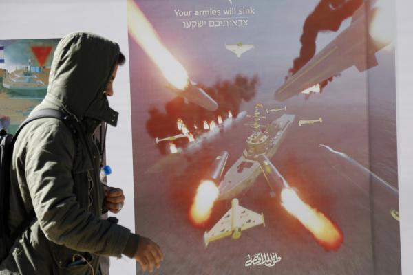 A man walks next to a billboard bearing the image missiles targeting ships on January 17, 2024, in Sanaa, Yemen. (Photo by Mohammed Hamoud/Getty Images)