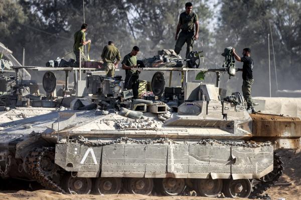 Israeli army soldiers check their gear atop an infantry fighting vehicle (IFV) stationed at a position along the border with the Gaza Strip and southern Israel on July 14, 2024. (Photo by Menahem Kahana/AFP via Getty Images)