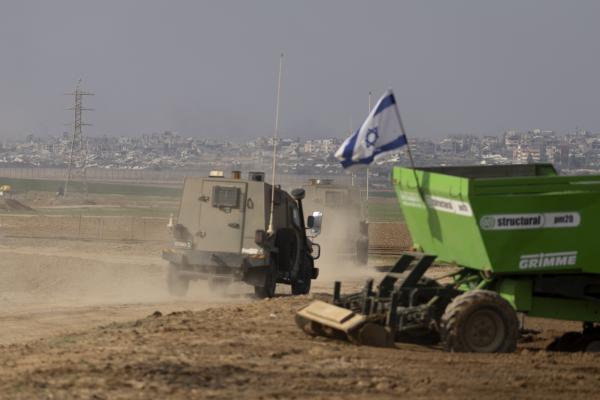 An Israeli army vehicle passes by an Israeli tractor working along the border with the Gaza Strip on January 16, 2025, in Israel. (Amir Levy via Getty Images)