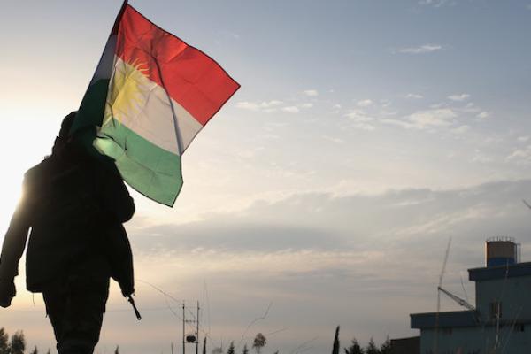 A Peshmerga soldier walk to place a Kurdish flag near the frontline with ISIL on November 16, 2015 in Sinjar, Iraq. (John Moore/Getty Images)