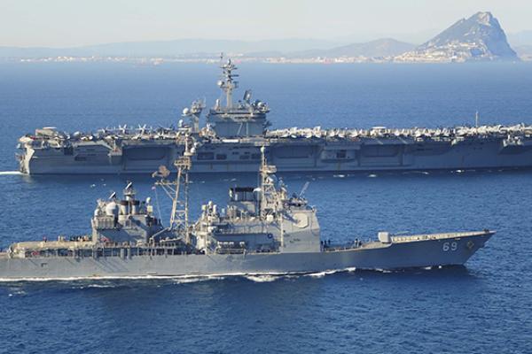 USS Vicksburg escorts the Nimitz-class aircraft carrier USS Theodore Roosevelt by the Rock of Gibraltar, March 31, 2015 (Anthony Hopkins II/U.S. Navy via Getty Images)