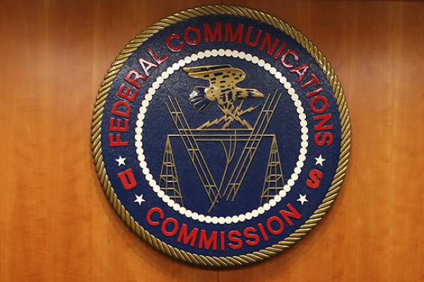 The seal of the Federal Communications Commission hangs behind commissioner Tom Wheeler's chair inside the hearing room at the FCC headquarters February 26, 2015 in Washington, DC. The Commission will vote on Internet rules, grounded in multiple sources o