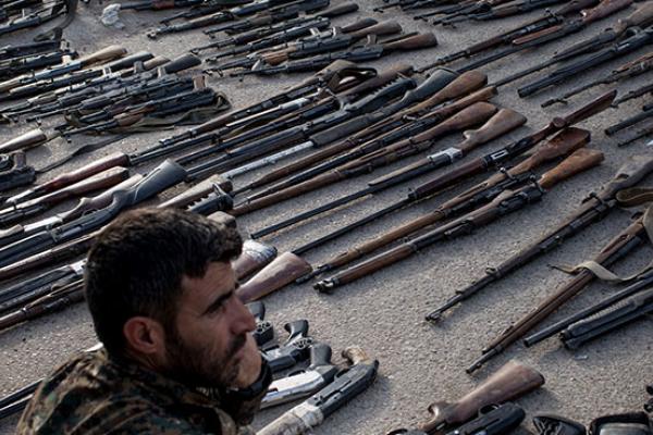 An Syrian Democratic Forces (SDF) fighter looks over seized ISIL weapons that were found in the last stronghold of the extremist group as they were displayed at an SDF base outside Al Mayadin, Syria.