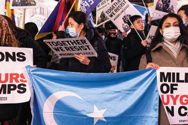 Protesters hold the Uyghur flag and placards that say "Millions of Uyghurs in Camps" during a protest in London, United Kingdom, on December 10, 2021. (Getty Images)