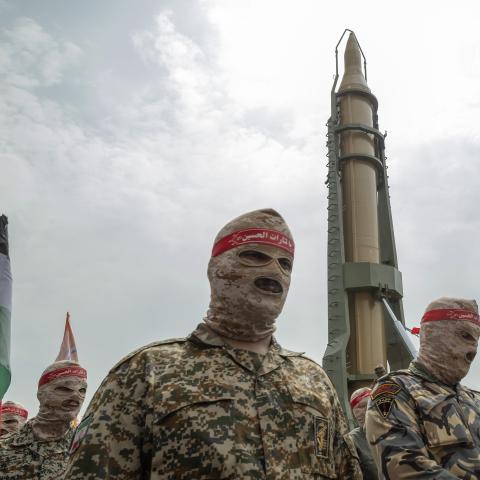 Members of the IRGC parade under an Iranian Kheibar Shekan Ballistic missile in downtown Tehran on April 29, 2022. (Morteza Nikoubazl/NurPhoto via Getty Images)