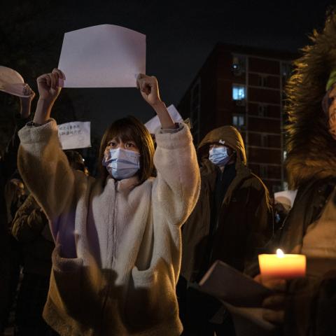 A protester holds up a white piece of paper against censorship as they march during a protest against Chinas strict zero COVID measures on November 27, 2022 in Beijing, China. 