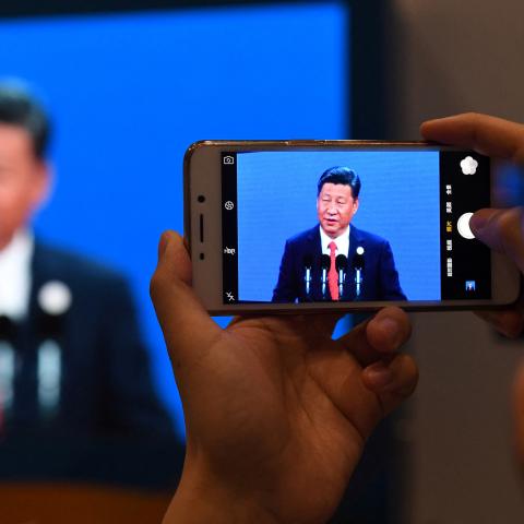 A journalist takes a photo of a live feed of Xi Jinping speaking at the opening ceremony of the Belt and Road Forum in Beijing, China, on May 14, 2017. (Greg Baker/AFP via Getty Images)