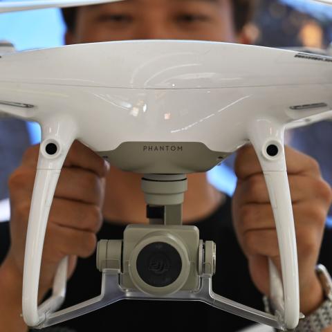 An employee shows a Phantom DJI drone at a store in Shanghai on May 27, 2019. (Hector Retamal/AFP via Getty Images)