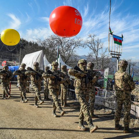 Azerbaijani servicemen stand guard at a checkpoint at the Lachin corridor, the Armenian-populated breakaway Nagorno-Karabakh region's only land link with Armenia, as Azerbaijani environmental activists protest against what they claim the illegal mining, on December 27, 2022. - Azerbaijani activists who have blocked the sole road connecting Karabakh with Armenia rejected on December 26 Yerevan's accusations of provoking a humanitarian crisis in the enclave. But locals in Karabakh interviewed by AFP decried t