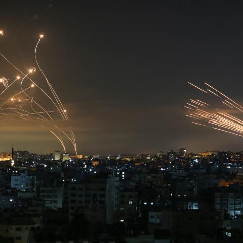 TOPSHOT - The Israeli Iron Dome missile defence system (L) intercepts rockets (R) fired by the Hamas movement towards southern Israel from Beit Lahia in the northern Gaza Strip as seen in the sky above the Gaza Strip overnight on May 14, 2021. - Israel bombarded Gaza with artillery and air strikes on Friday, May 14, in response to a new barrage of rocket fire from the Hamas-run enclave, but stopped short of a ground offensive in the conflict that has now claimed more than 100 Palestinian lives. As the viole