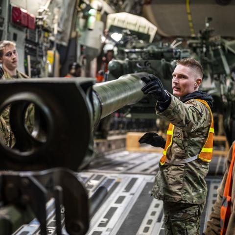 Senior Airman Trent Sloat, 435th Contingency Response Wing air transportation journeyman, directs a forklift that is off loading a M777 howitizer from a C-17 Globemaster III in Eastern Europe, May 2, 2022. The security assistance the U.S. is providing to Ukraine is enabling critical success on the battlefield against the Russian invading force. (U.S. Air Force photo by Staff Sgt. Shawn White)