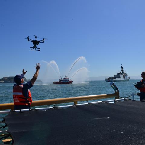 Coast Guard Lt. Trevor Clark prepares to land a Short Range Unmanned Aerial System (SR-UAS) ‘drone’ on the deck of the Coast Guard Cutter Tern with the help of a crew member after operating the vehicle around the Coast Guard Cutter Bertholf (WMSL 750) during the cutter’s return home to Alameda, California, July, 2, 2019, following their 164-day deployment to the Western Pacific.