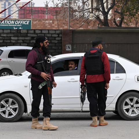 Policemen stand guard along a street in Peshawar, Pakistan, on February 1, 2023. (Farooq Naeem/AFP via Getty Images) 