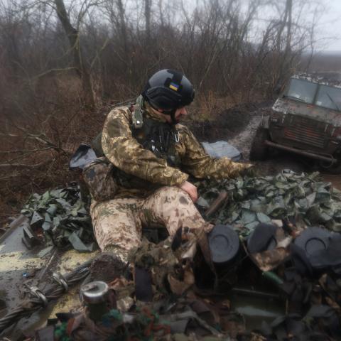 Ukrainian military member drives sitting on top of armored vehicle on a dirt road on February 26, 2023 in Donetsk Oblast, Ukraine. After the withdrawal of Ukrainian troops from Soledar, the main confrontation with the Russian army and its mercenaries take place in February on the outskirts of the city of Bakhmut in the Donetsk Oblast. (Photo by Yan Dobronosov/Global Images Ukraine via Getty Images)