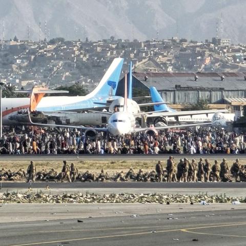 Crowds fill the tarmac while coalition forces form a security perimeter around the runway at Kabul International Airport, Afghanistan, Aug. 16, 2021. Once airborne, aircrew assigned to the U-28A Draco provided surveillance and reconnaissance of the ground situation at the airport during the U.S. withdrawal from Afghanistan. (U.S. Air Force photo courtesy of Lt. Col. Scott Hardman)