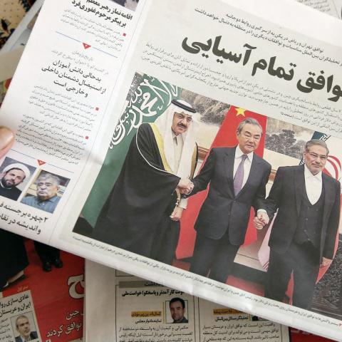 A man in Tehran holds a local newspaper reporting on the China-brokered deal between Iran and Saudi Arabia to restore ties signed in Beijing, on March 11, 2023. (Atta Kenare/AFP via Getty Images)