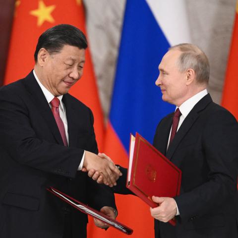 Russian President Vladimir Putin and Chinese President Xi Jinping shake hands during a reception following their talks at the Kremlin on March 21, 2023. (Photo by Pavel Byrkin / SPUTNIK / AFP)