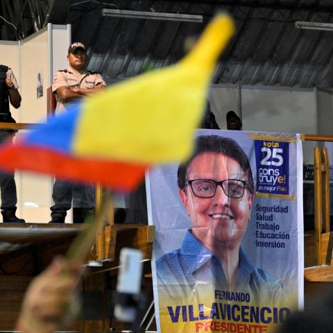 Policemen stand guard while supporters of slain Ecuadorian presidential candidate Fernando Villavicencio pay their respects during an act organized by the Movimiento Construye party and friends at the Quito Exhibition Center in Quito on August 11, 2023. (Rodrigo Buendia/AFP via Getty Images)