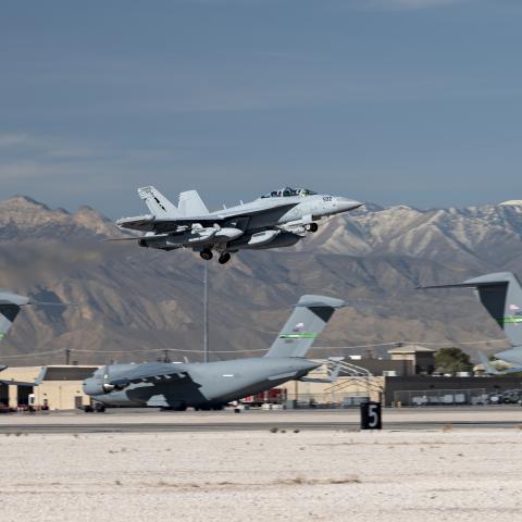 A Navy EA-18G aircraft takes off during a US Air Force Weapons School Integration (WSINT) exercise at Nellis Air Force Base on November 21, 2022. (US Air Force photo by William R. Lewis)