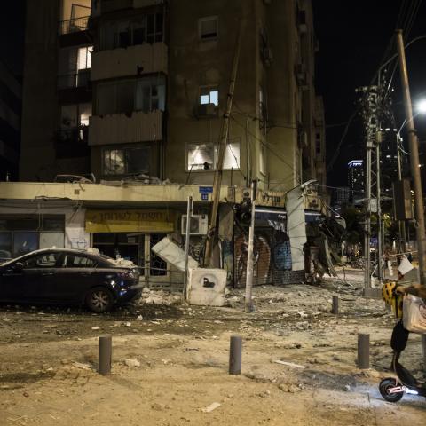 A man passes the scene where a rocket fired from Gaza strip hit a building on October 7, 2023, in Tel Aviv, Israel. (Photo by Amir Levy via Getty Images)