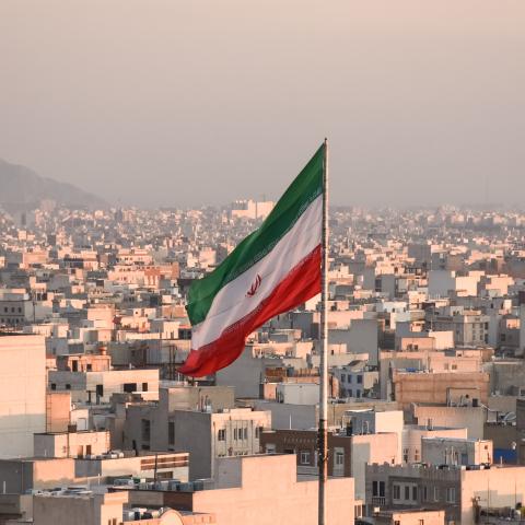 Iranian flag waving with city skyline on background in Tehran, Iran. (Sir Francis Canker Photography via Getty Images) 
