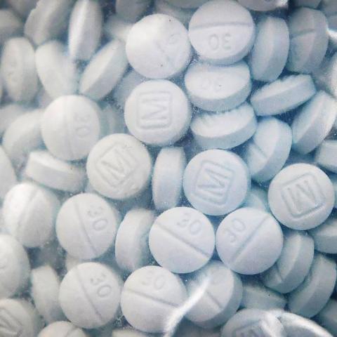 A bag of evidence containing the synthetic opioid fentanyl disguised as Oxycodone is shown during a 2020 news conference at the Fresno County Sheriff Office in Fresno, California. (Craig Kohlruss/The Fresno Bee/Tribune News Service via Getty Images)