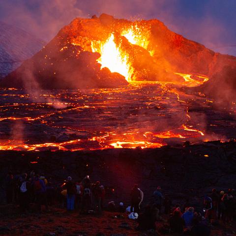 People's figures are illuminated by the glow of the lava on March 28, 2021 on the Reykjanes Peninsula, Iceland. The Mount Fagradalsfjall volcano erupted on March 19, after thousands of small earthquakes in the area over the recent weeks, and was reportedly the first eruption of its kind on the Reykjanes Peninsula in around 800 years. (Photo by Sophia Groves/Getty Images)