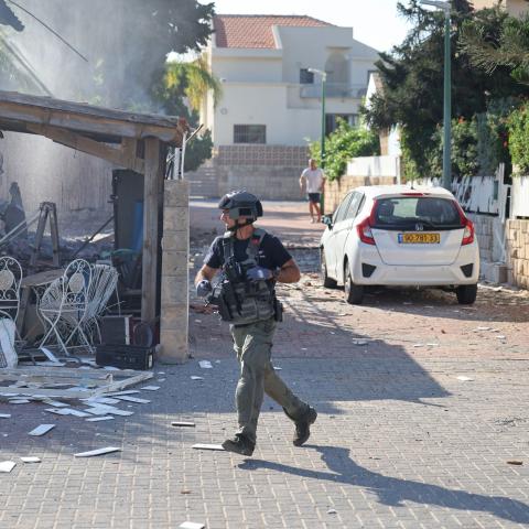  A member of the Israeli forces runs past a fire raging in a house in Ashkelon following a rocket attack from the Gaza Strip on southern Israel on October 7, 2023. Palestinian militant group Hamas has launched a "war" against Israel, Defence Minister Yoav Gallant said, after barrages of rockets were fired from the Gaza Strip into Israeli territory on October 7. (Photo by AHMAD GHARABLI / AFP) (Photo by AHMAD GHARABLI/AFP via Getty Images)