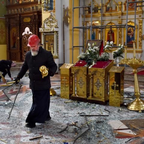 An Orthodox priest collects religious objects as others clear up glass and debris inside the Holy Intercession Cathedral damaged after missile strikes, in Zaporizhzhia on October 18, 2023. (Andriy Andriyenko/AFP via Getty Images)