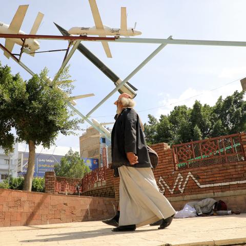 Yemenis walk past an installation depicting military drones in Sanaa on November 16, 2023, amid ongoing battles between Israel and the Palestinian group Hamas in the Gaza Strip. Yemen's Huthi rebels on November 13, threatened to target Israeli ships in the Red Sea, as the group said they had launched another missile targeting the country over its war with Hamas. (Photo by MOHAMMED HUWAIS / AFP) (Photo by MOHAMMED HUWAIS/AFP via Getty Images)