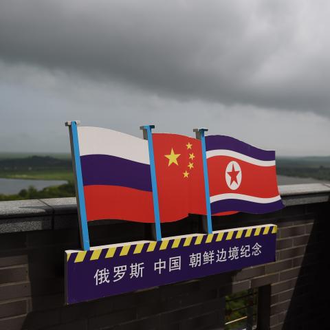 The flags of Russia, China, and North Korea on a viewing tower on the border between the three countries in Hunchun, China, on June 25, 2015. (Greg Baker/AFP via Getty Images)