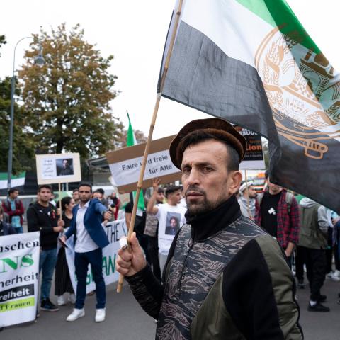 A supporter of Ahmad Massoud, leader of the National Resistance Front of Afghanistan (NFR) and the leading Afghan fighter against the Taliban, holds a flag with an NRF logo as he demonstrates outside Concordia Press Club in Vienna, Austria, on September 16, 2022. (Joe Klamar/AFP via Getty Images)