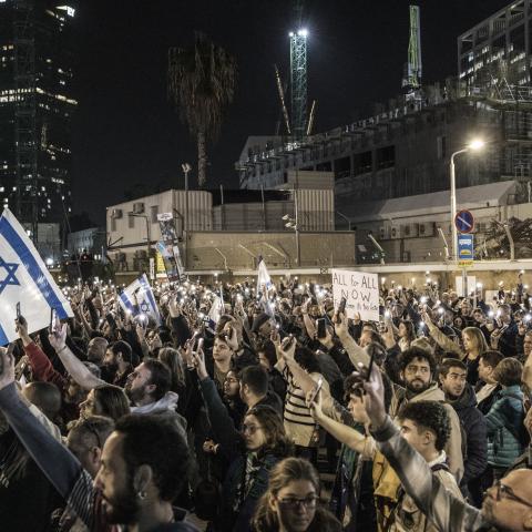 Demonstrators outside the Tel Aviv Museum of Art, now informally called the "Hostages Square," in Tel Aviv hold up their lit mobile phones as they gather during a demonstration calling for the release of hostages on December 9, 2023. (Marco Longari/AFP via Getty Images) 
