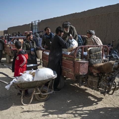 Afghan men load food packets from the World Food Programme onto a vehicle in Baraki Barak, Afghanistan, on January 7, 2024. (Wakil Kohsar/AFP via Getty Images)