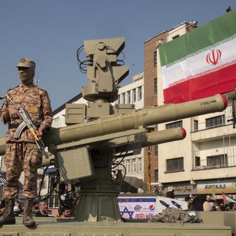 Two Islamic Revolutionary Guard Corps armed military personnel are monitoring an area while standing guard next to an Iranian Majid anti-aircraft missile system during the Ela Beit Al-Moghaddas military rally in Tehran, Iran, on November 24, 2023. (Morteza Nikoubazl/NurPhoto via Getty Images)