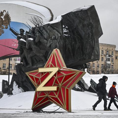 People walk past a Kremlin Star, bearing a Z letter, an insignia of Russian troops in Ukraine, in front of the Monument dedicated to Heroes of the WWI, in western Moscow. (Alexander Nemenov via Getty Images)