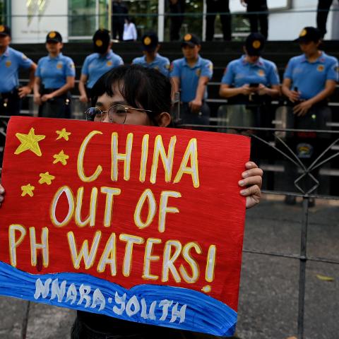 A protester raises a placard during a demonstration to condemn China's aggression in the disputed South China Sea in front of the Chinese Consulate in Makati, Metro Manila, on February 6, 2024. (Jam Sta Rosa/AFP and Getty Images)