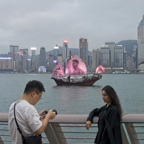  A fan poses for a photo as a sailing ship bearing a portrait of Inter Miami CF's Argentine forward Lionel Messi sails across the Victoria Harbor on February 3, 2024, in Hong Kong, China. (VCG/VCG via Getty Images)
