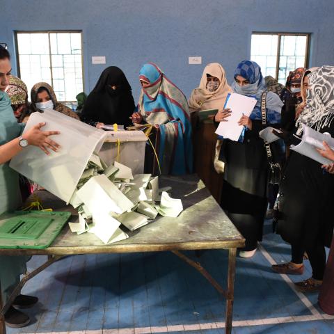 Polling staff open ballot boxes in the presence of poling agents from various political parties as they start counting votes at the end of Pakistan's national elections on February 8, 2024. (Banaras Khan/AFP via Getty Images)