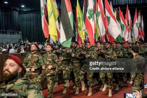 Pro-Iranian Hezbollah militants march with Lebanese, Palestinian and Hezbollah flags during a mass rally to mark al-Quds Day (Jerusalem Day).